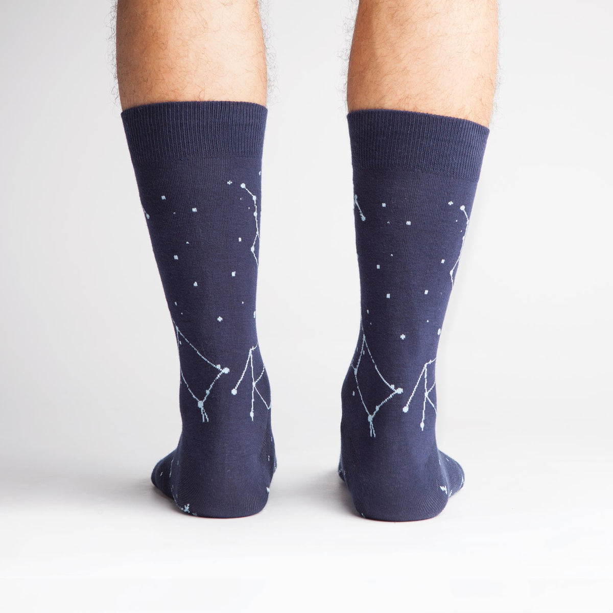 Sock It To Me Constellation (GLOWS IN THE DARK!) men&#39;s navy blue sock featuring constellations all over worn by model from back