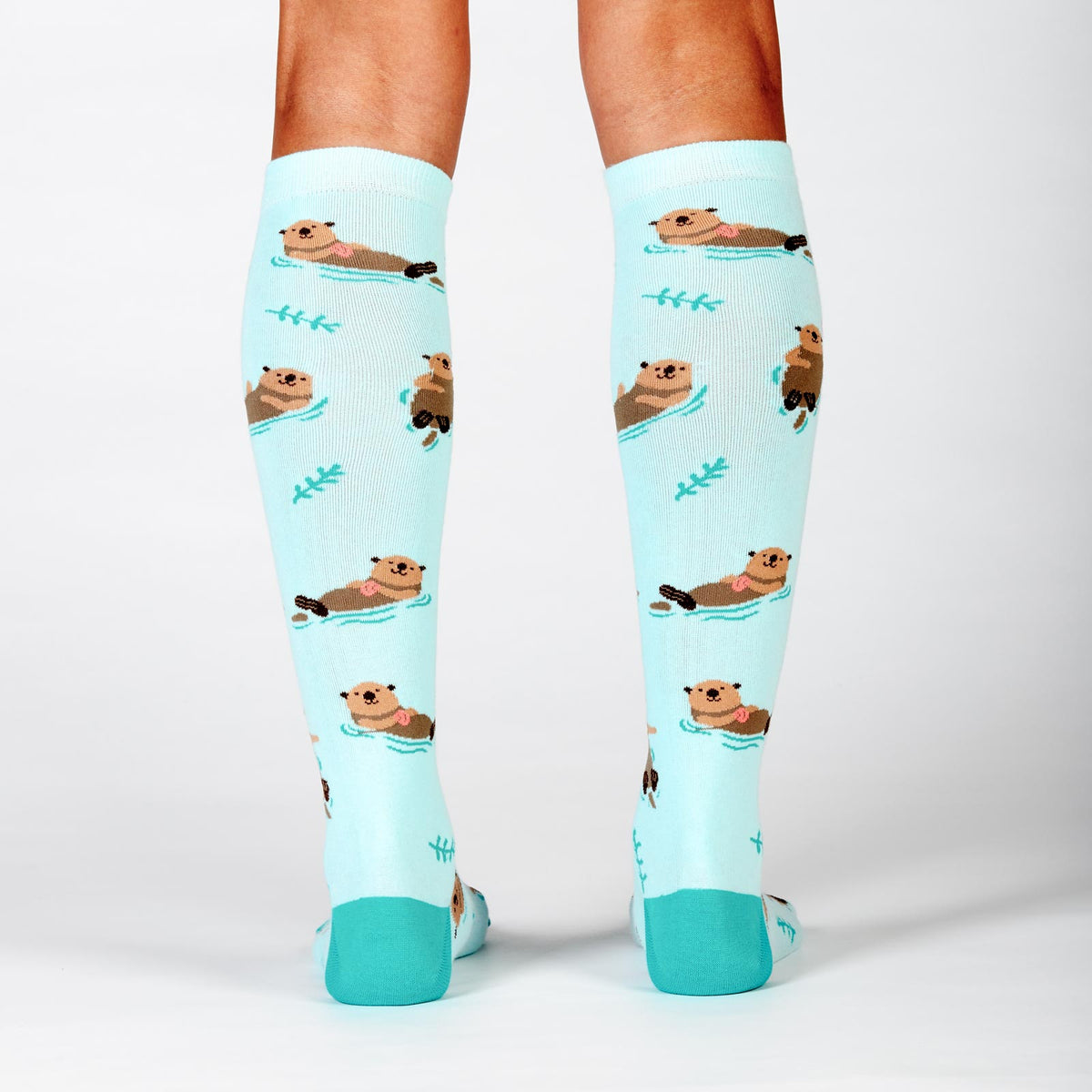 Sock It To Me My Otter Half women&#39;s socks on model from back showing otters in ocean 